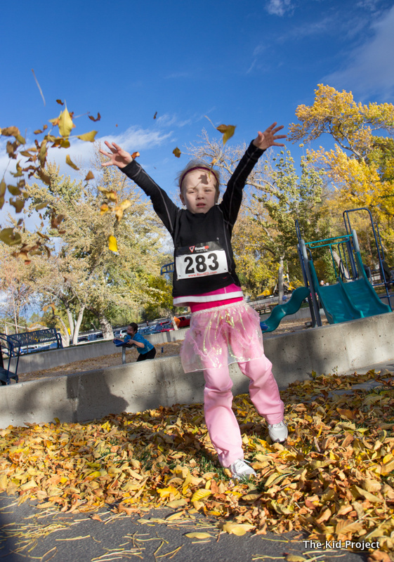 girl tossing leaves