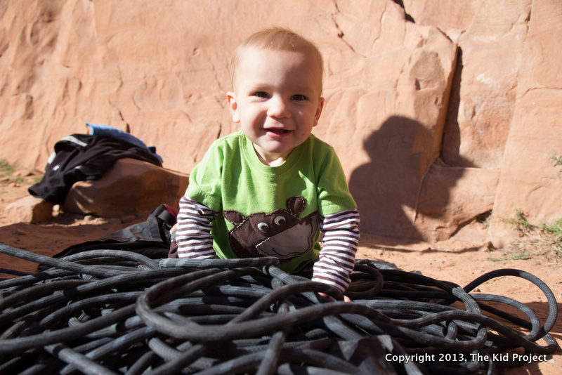 baby playing in the climbing ropes