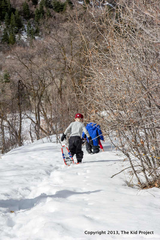 Boys snowshoe in forest