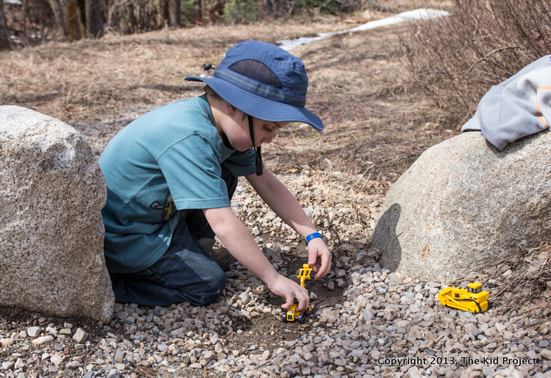 boy playing with tractors in dirt