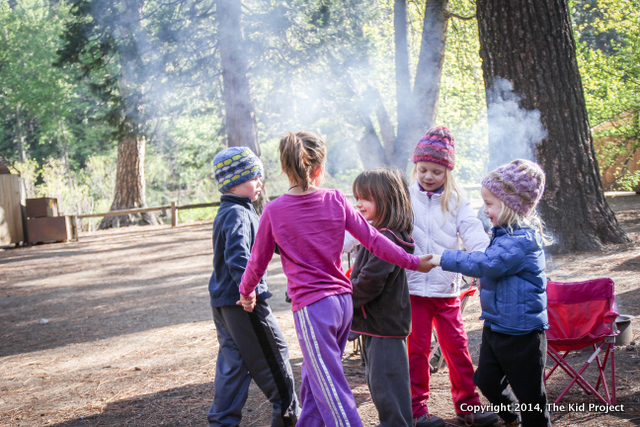 kids playing around campfire